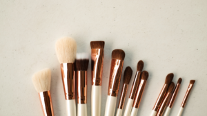 This image shows a lot of makeup brushes lined up next to each other.
