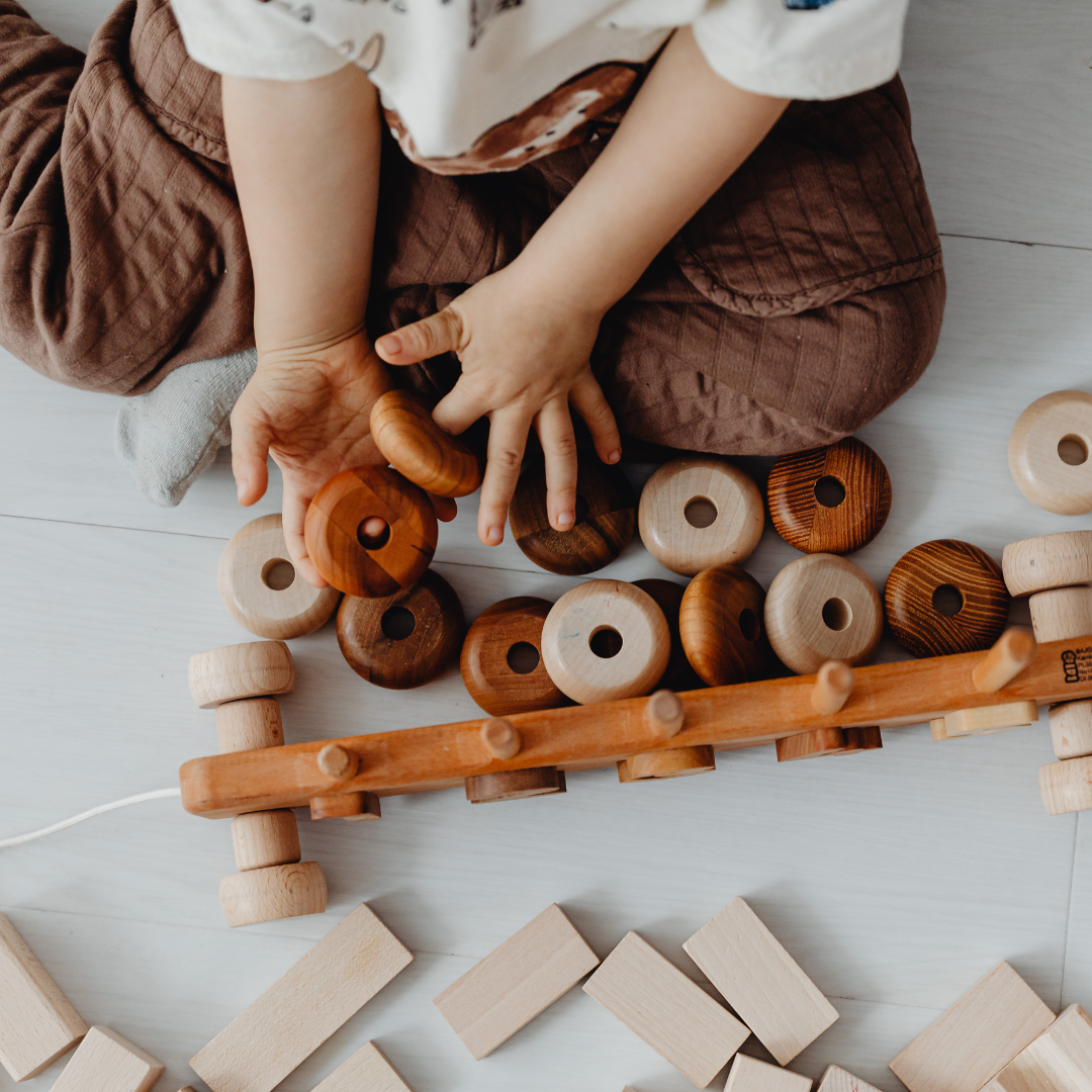 This image shows a child playing with wooden toys. This episode is about the foster care system.