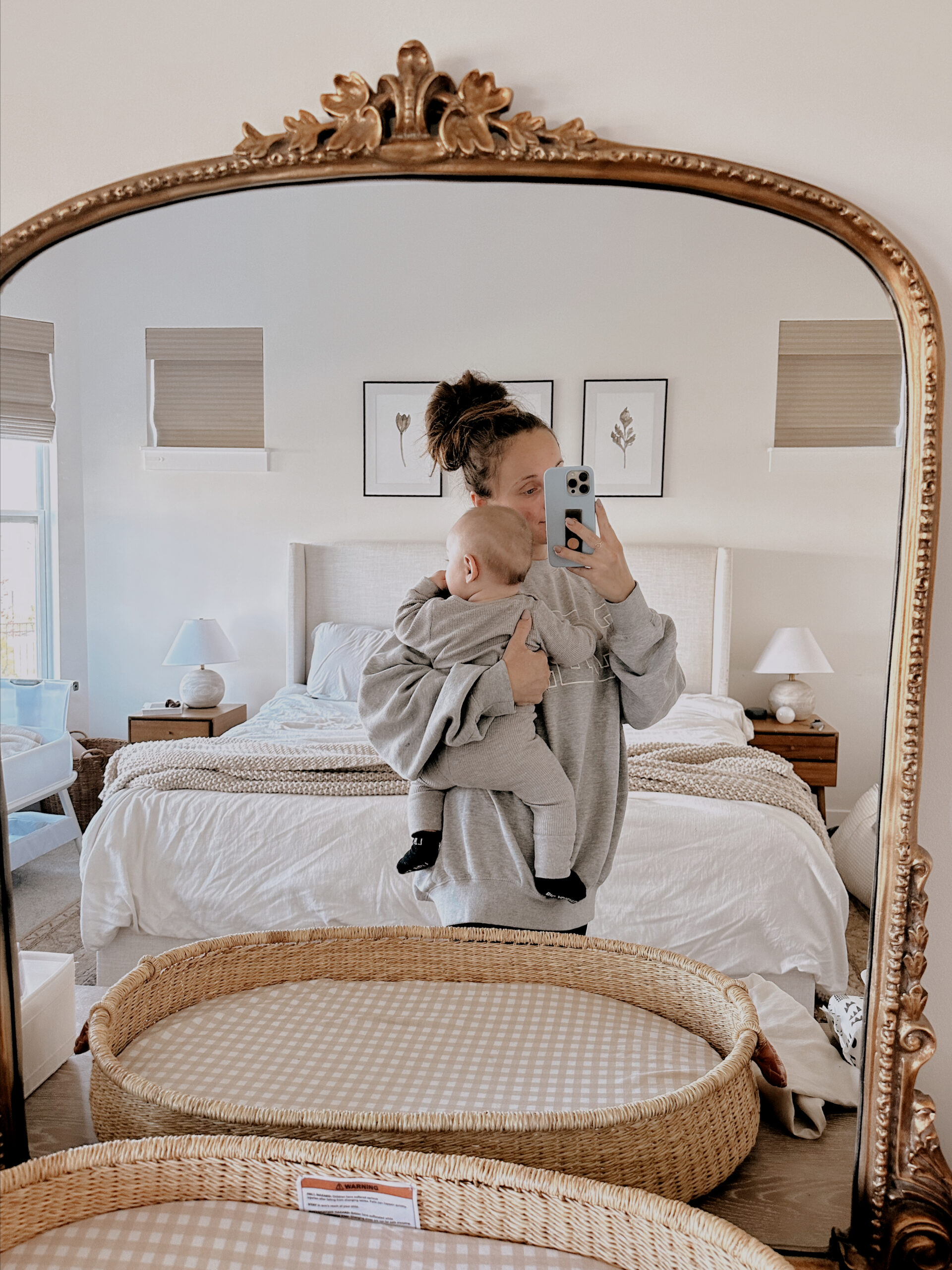 In this image, Jordan holds her son, with a camera in one hand, while looking at the mirror.