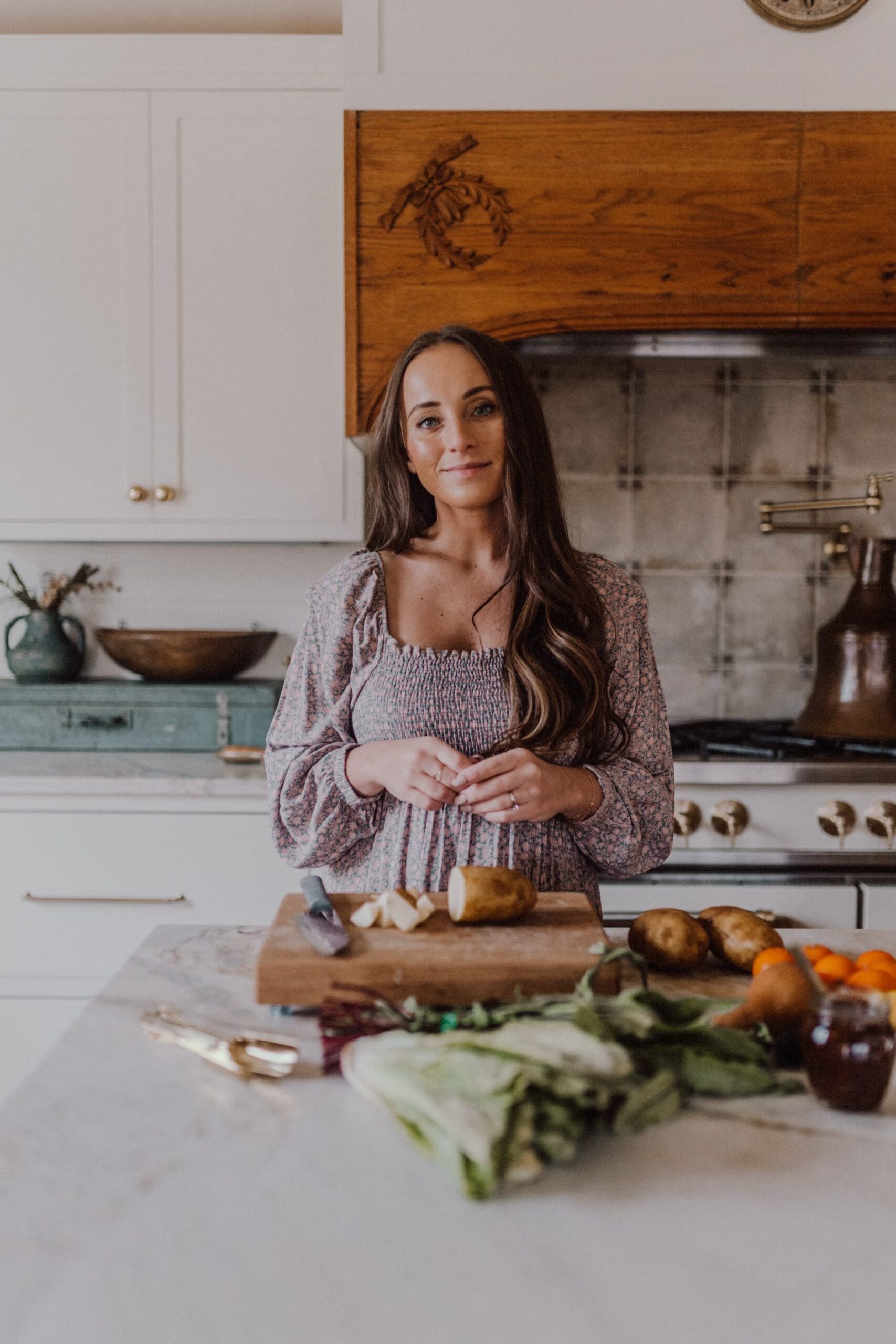 In this image, Jordan stands at a kitchen island, with fresh produce laid out in front of her. In this episode, Jordan talks about how yo restart your health journey when you've fallen off the bandwagon.