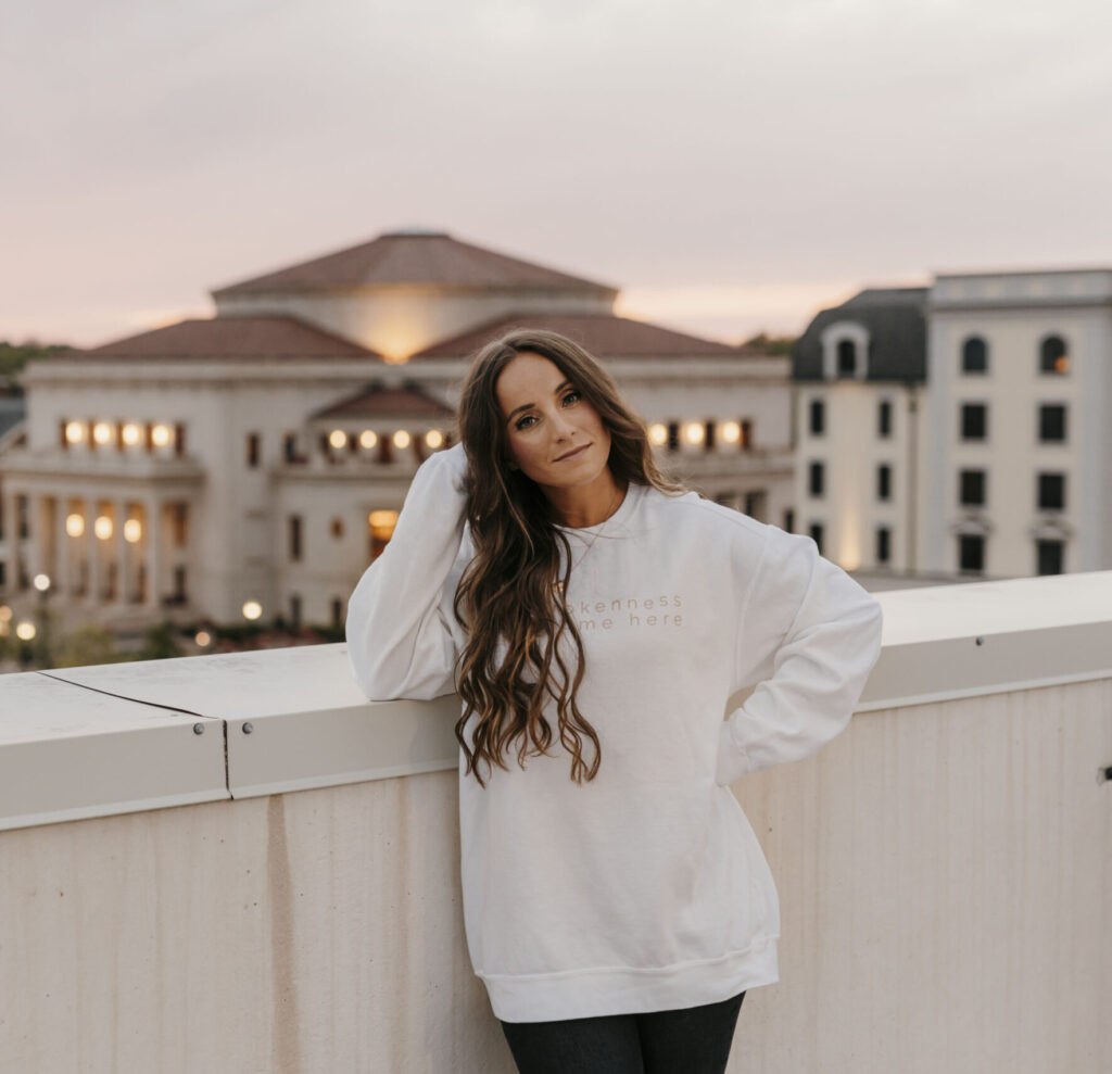 This image shows Jordan in leaning against a rooftop in the city at night.